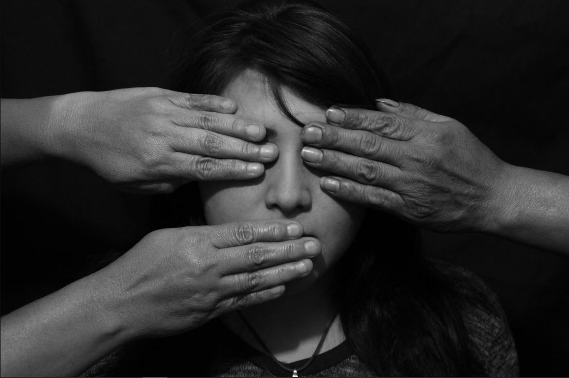 women with hands over eyes and mouth
